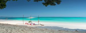 A shaded romantic breakfast table near the exotic turquoise waters and white sand beaches on Tsara Komba in Madagascar